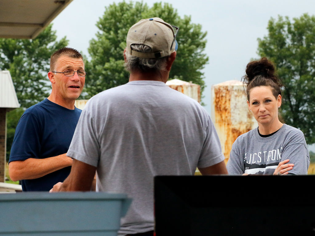 Greg and Taris Tellman talk to one of the participants of their community sale